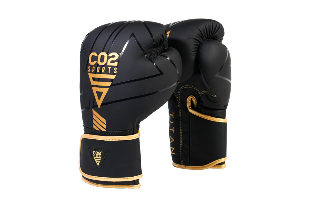 Black boxing gloves with gold accents and CO2 Sports branding on a white background
