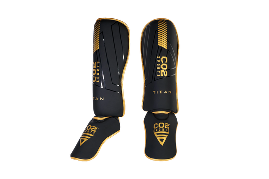 Black and gold shinguards with 'CO2 Sports' branding on a white background